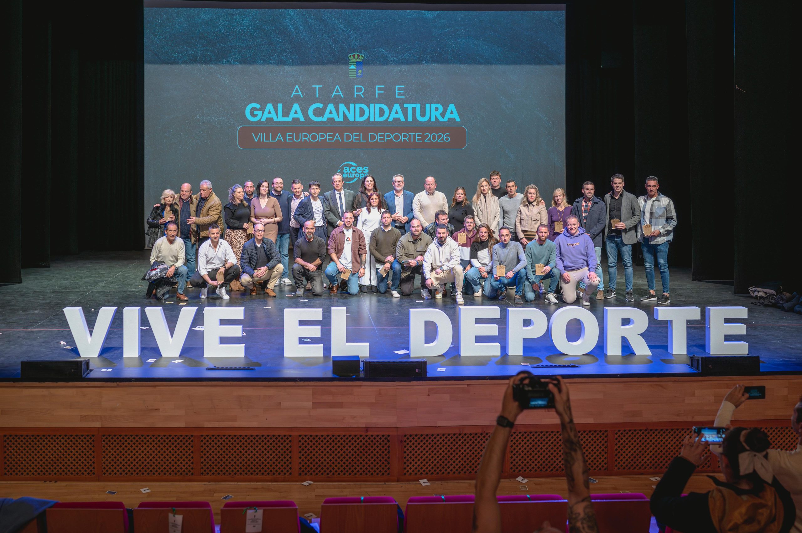 <img src="URL_DE_TU_IMAGEN" alt="Premiados del evento junto a la corporación municipal en la gala 'Candidatos a Villa Europea del Deporte 2026'" title="Premiados y corporación municipal - Gala Atarfe" />